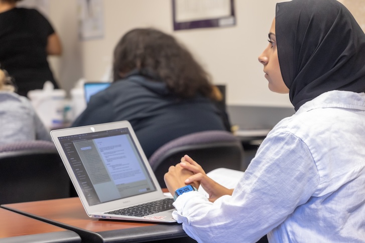 Student taking notes on laptop during class